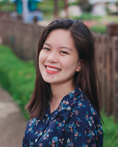 身着蓝色和红色花领上衣微笑的女性肖像摄影